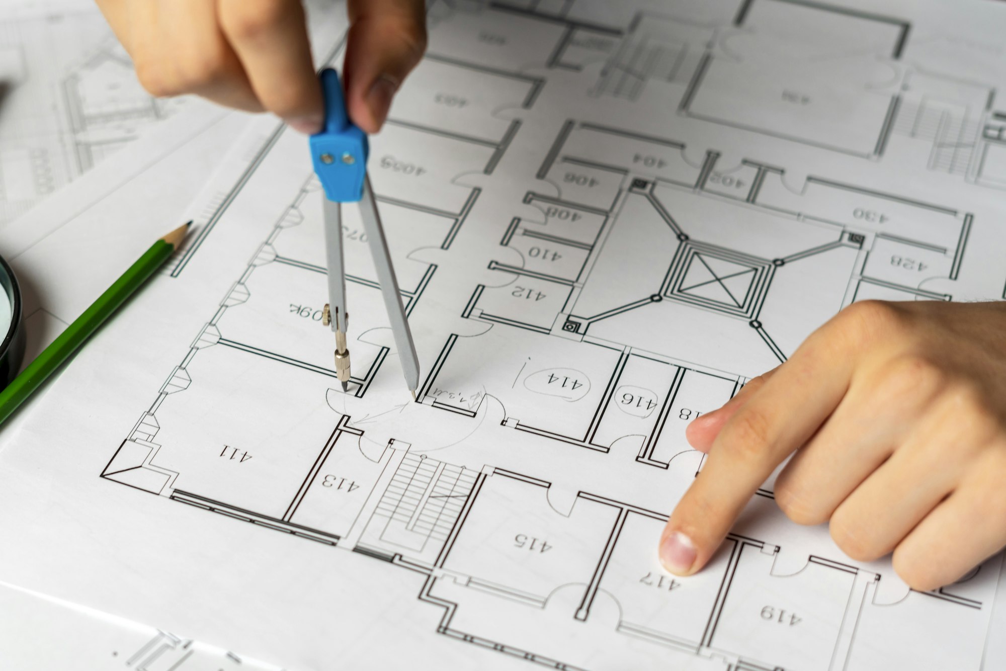 engineer sketching building project on a blueprint with a pencil b